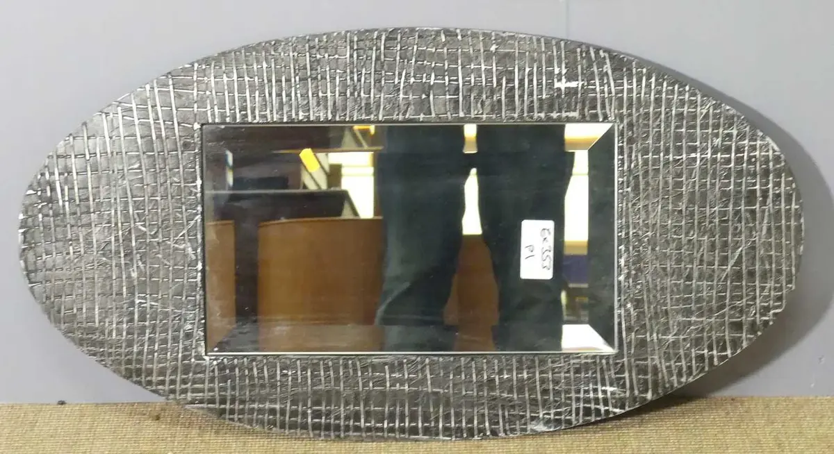 Lot 599 - A contemporary cast metal framed wall mirror