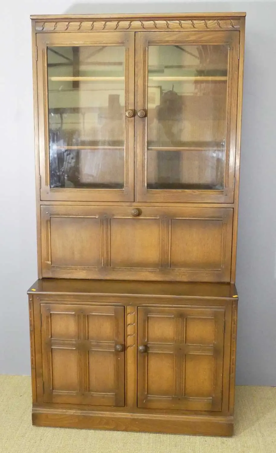 Lot 591 - An Ercol mid-elm wall unit, having twin