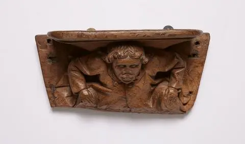 A carved oak miserichord with a figure