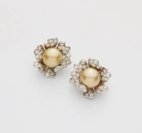 A pair of 18k white gold diamond and golden South Sea pearl clip earrings.
