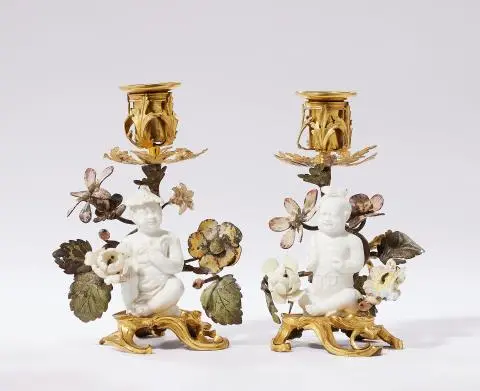 A pair of ormolu chambersticks with figures of children