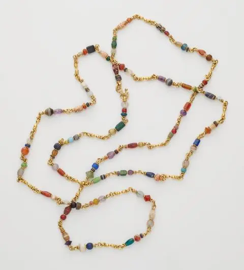 A forged 21.6k yellow gold and polychrome ancient Islamic glass and