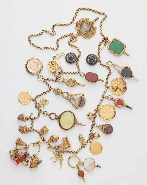 A long 9k gold chain with 30 partially multi-part gold and metal charms