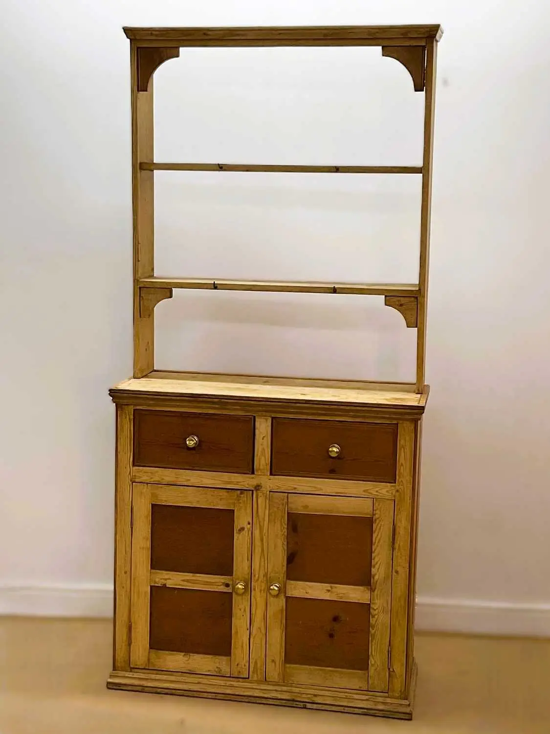 A pine kitchen dresser with open shelves over a two drawer