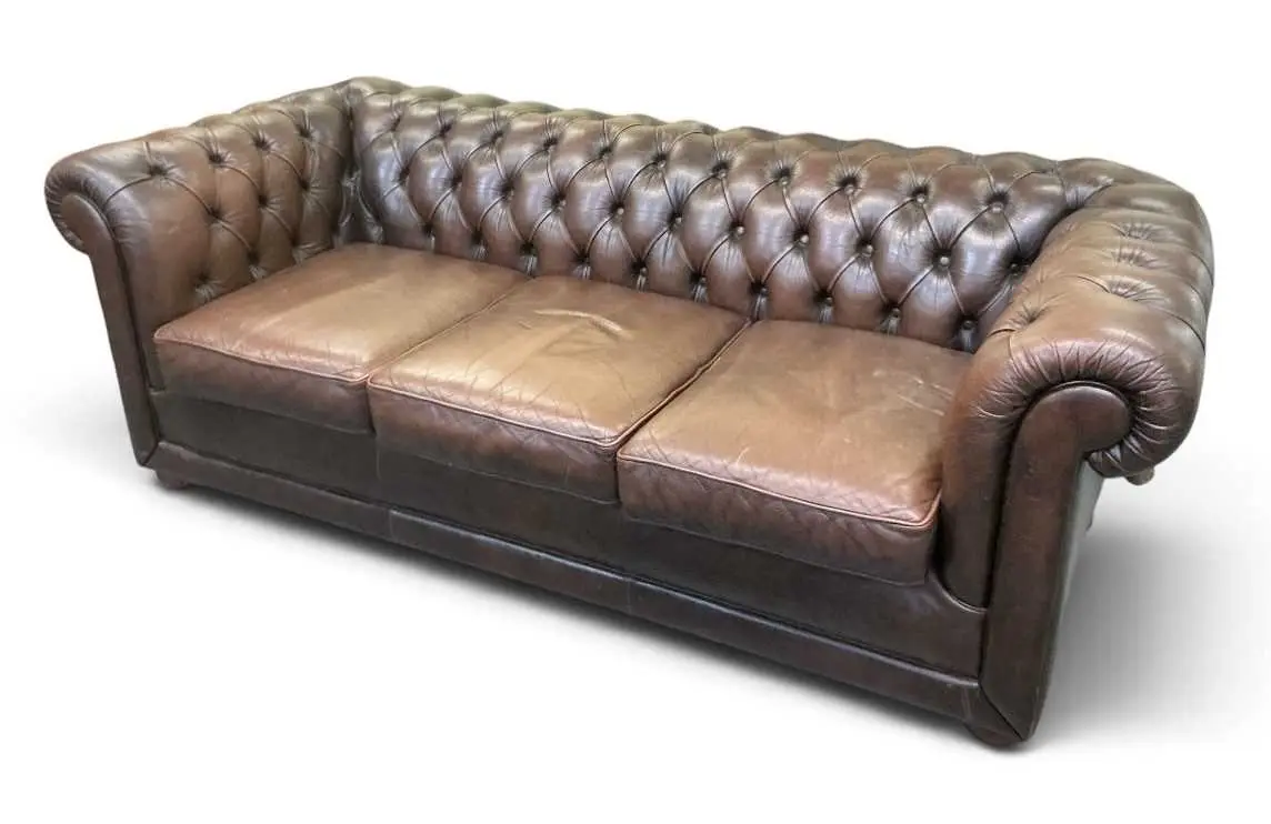 A modern brown button leather upholstered Chesterfield type three seater sofa