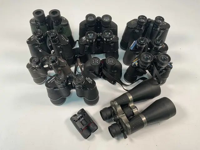 A quantity of binoculars with cases