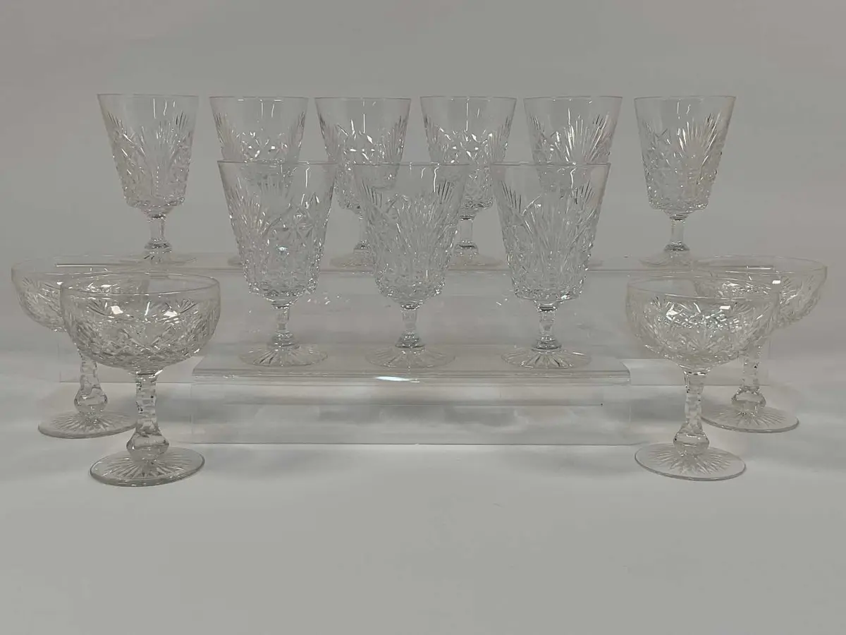 A quantity of cut crystal champagne coupes and wine glasses