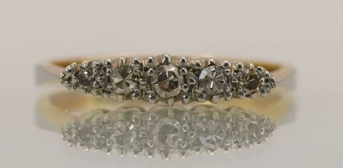 An 18ct yellow gold dress ring set with five tiny...