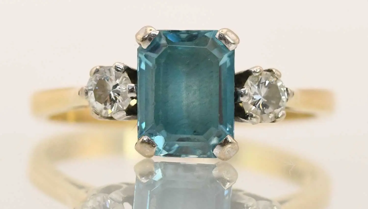 An 18ct yellow gold blue zircon and diamond set three stone ring