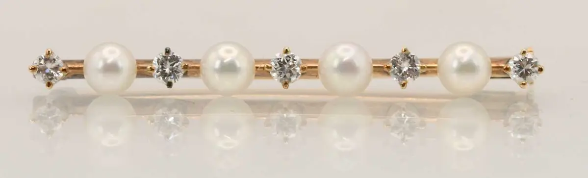 A 14ct yellow gold pearl and diamond set bar brooch