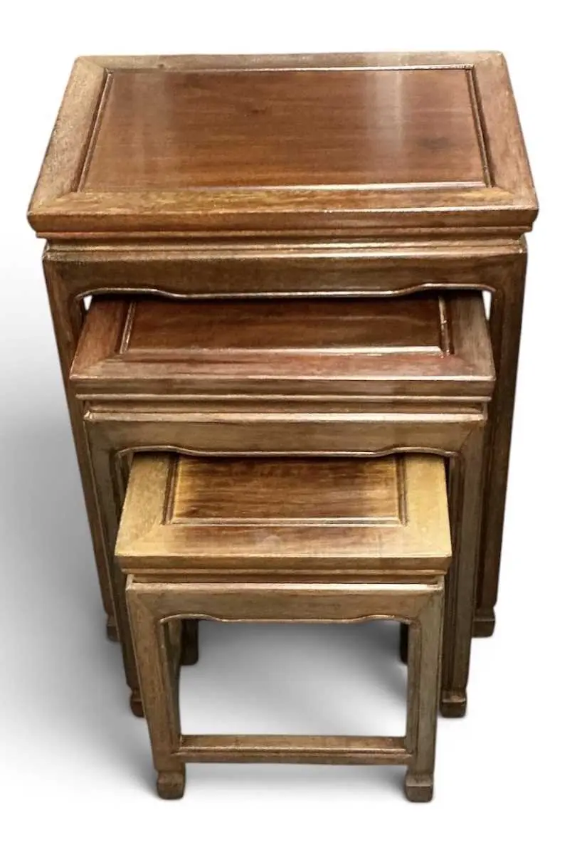 A modern Chinese carved hardwood nest of three occasional tables