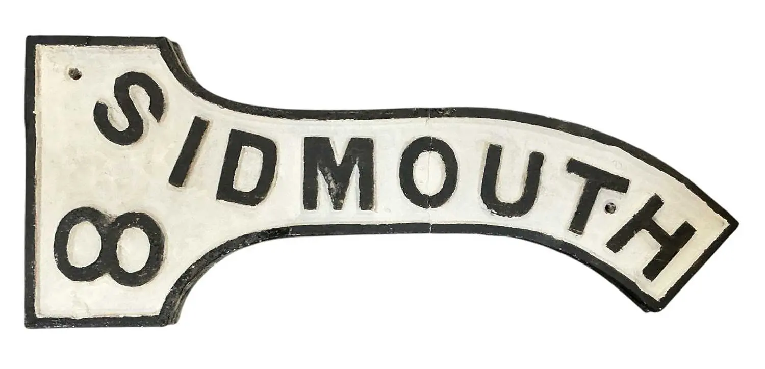 A vintage black and white painted cast iron street sign