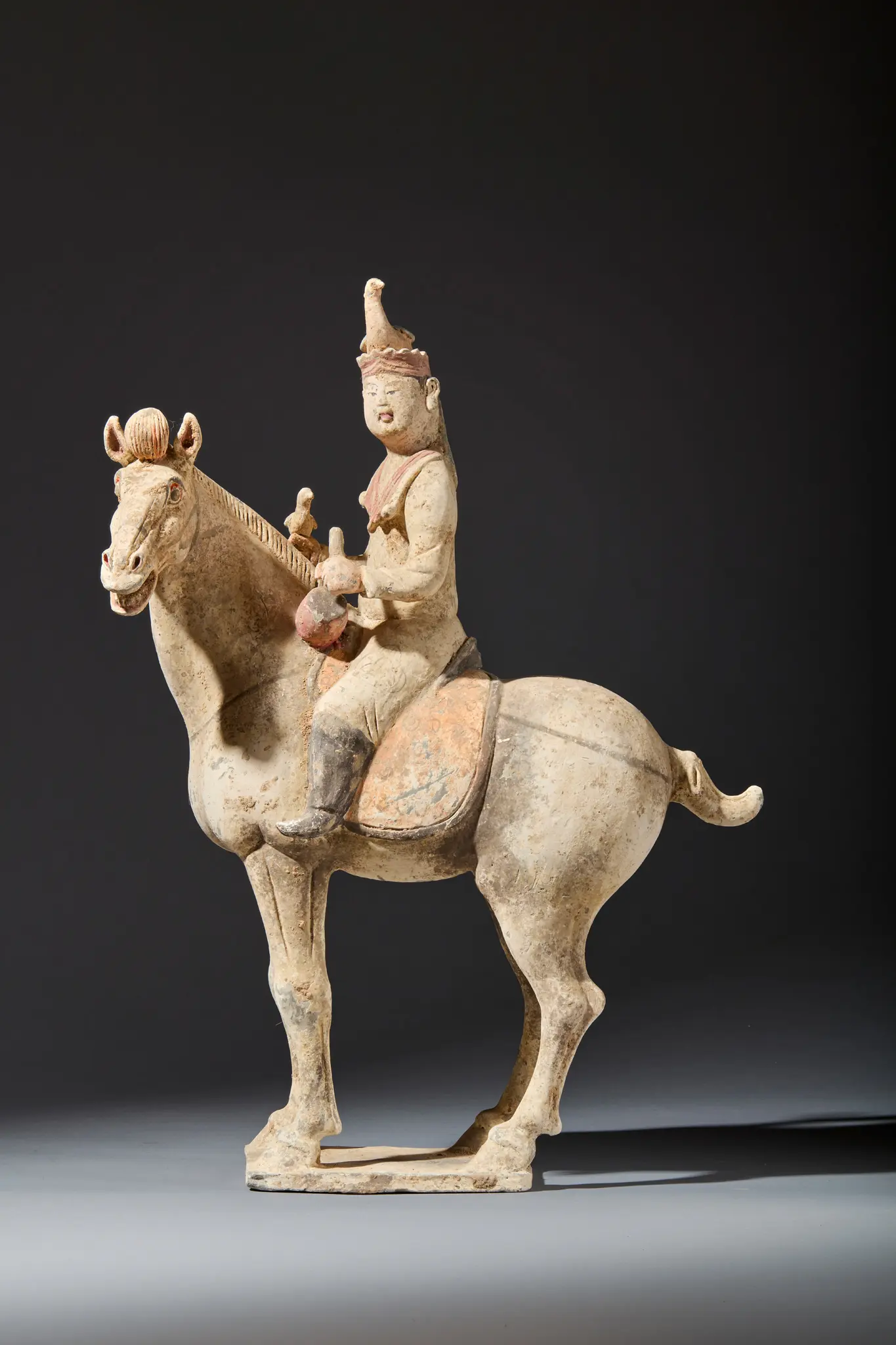 CHINESE PAINTED POTTERY HORSE WITH A MALE MUSICIAN