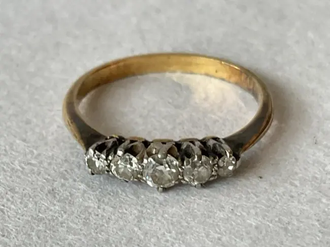 An 18ct gold five stone diamond ring claw set with graduated brilliant