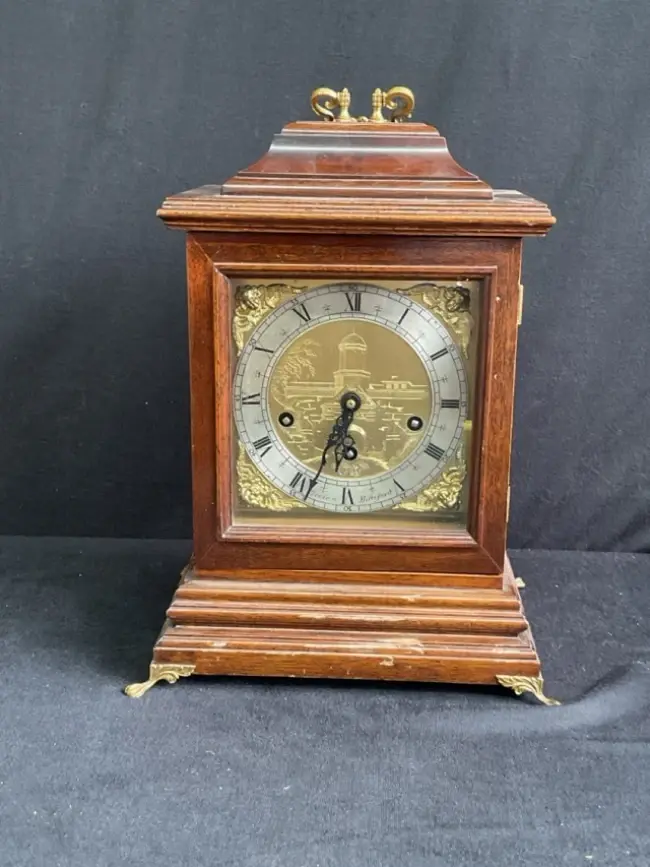 A Georgian style mahogany bracket clock with gilt brass handle, moulded