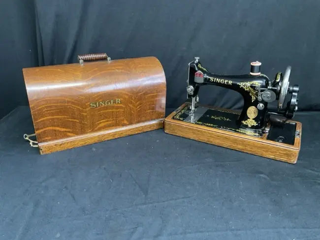 An Edwardian Singer sewing machine in domed oak case with ribbed swing