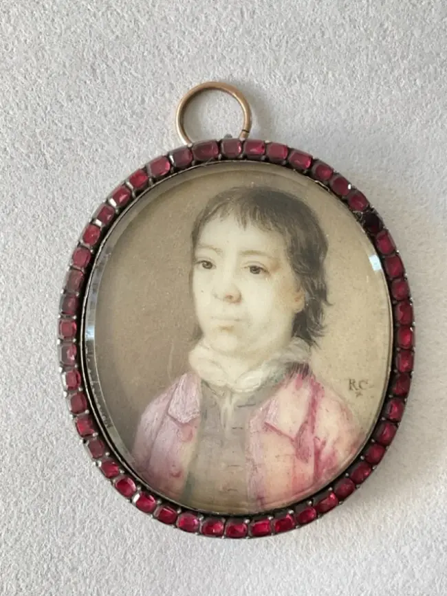 A late 18th century portrait miniature of a young man in a pink jacket