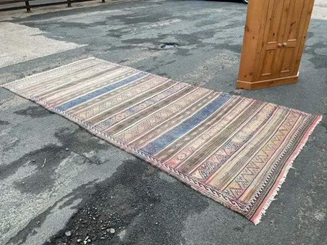 A Caucasian Soumak wool rug woven with stripes of stylised flowerheads