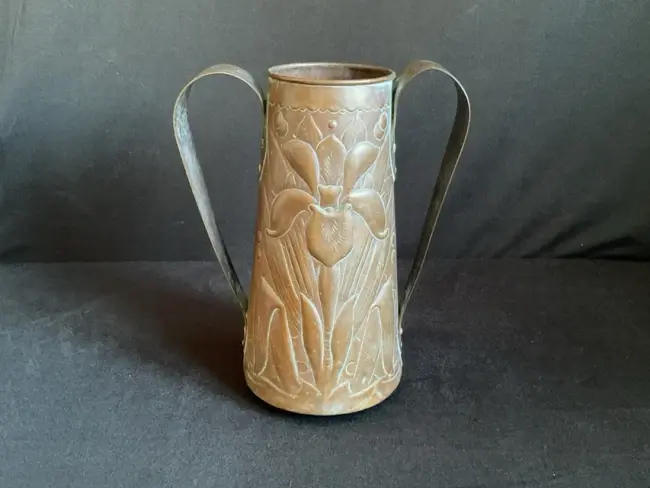 An art nouveau Newlyn tapering embossed copper vase, with two relief