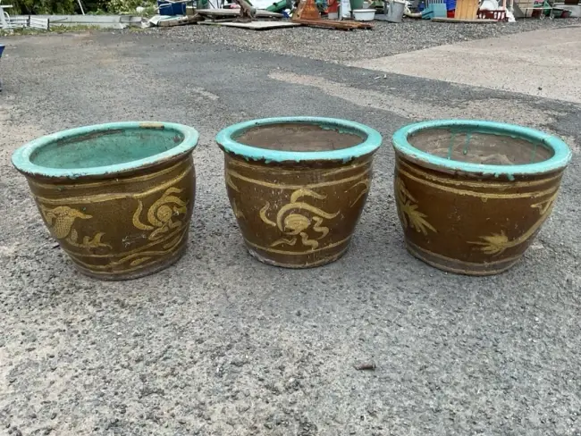 A set of three stoneware garden pots with turquoise glazed moulded
