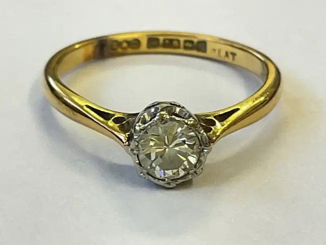 A hallmarked 18ct gold and platinum solitaire diamond ring set with