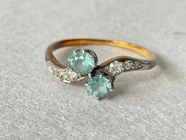 An antique 18ct gold ring set with a pair of blue zircons, each having