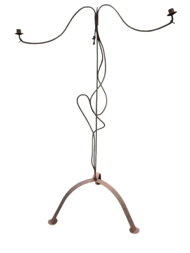 A rusty old wrought iron candelabra with wavy branches and supports