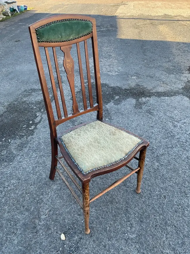 An art nouveau chair with inlaid vase to splat beneath stud upholstered