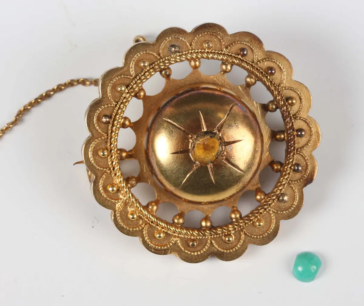 A Victorian gold brooch of shaped circular form with applied bead