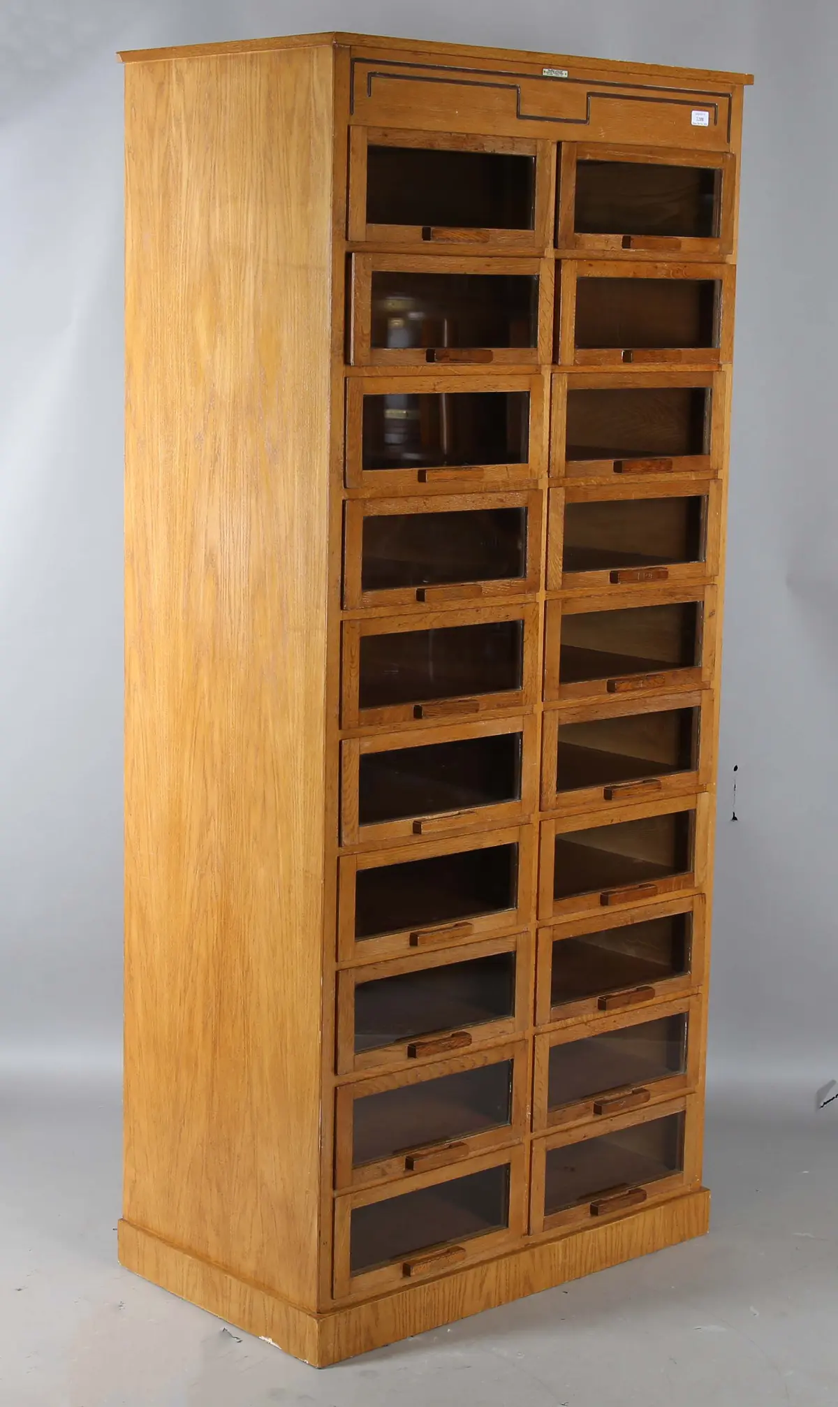 An Art Deco oak haberdashery cabinet by Dudley & Co Ltd, London, fitted