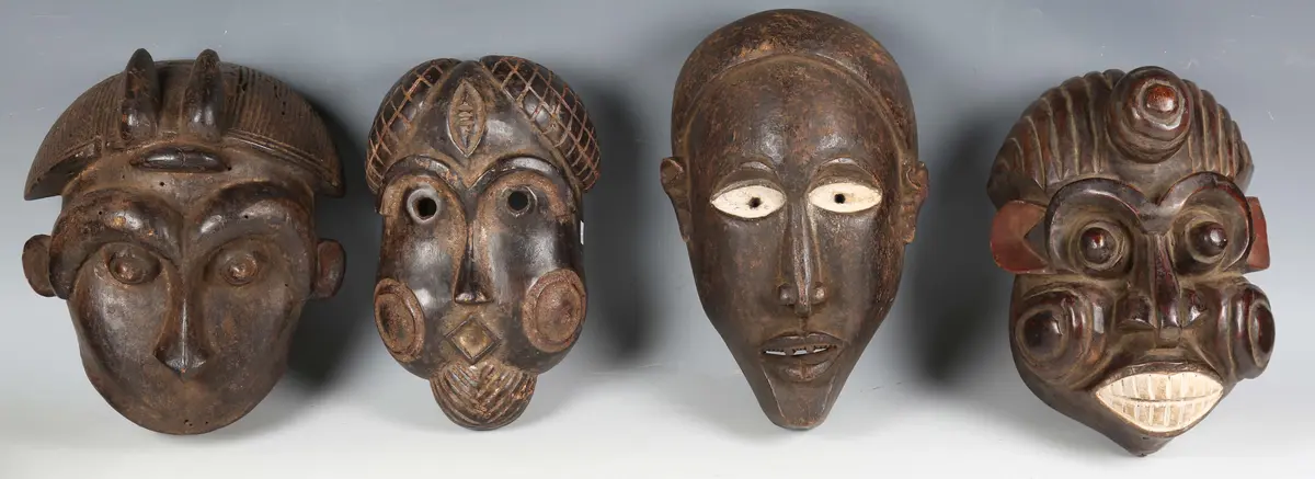A group of four African carved and painted wooden masks of various