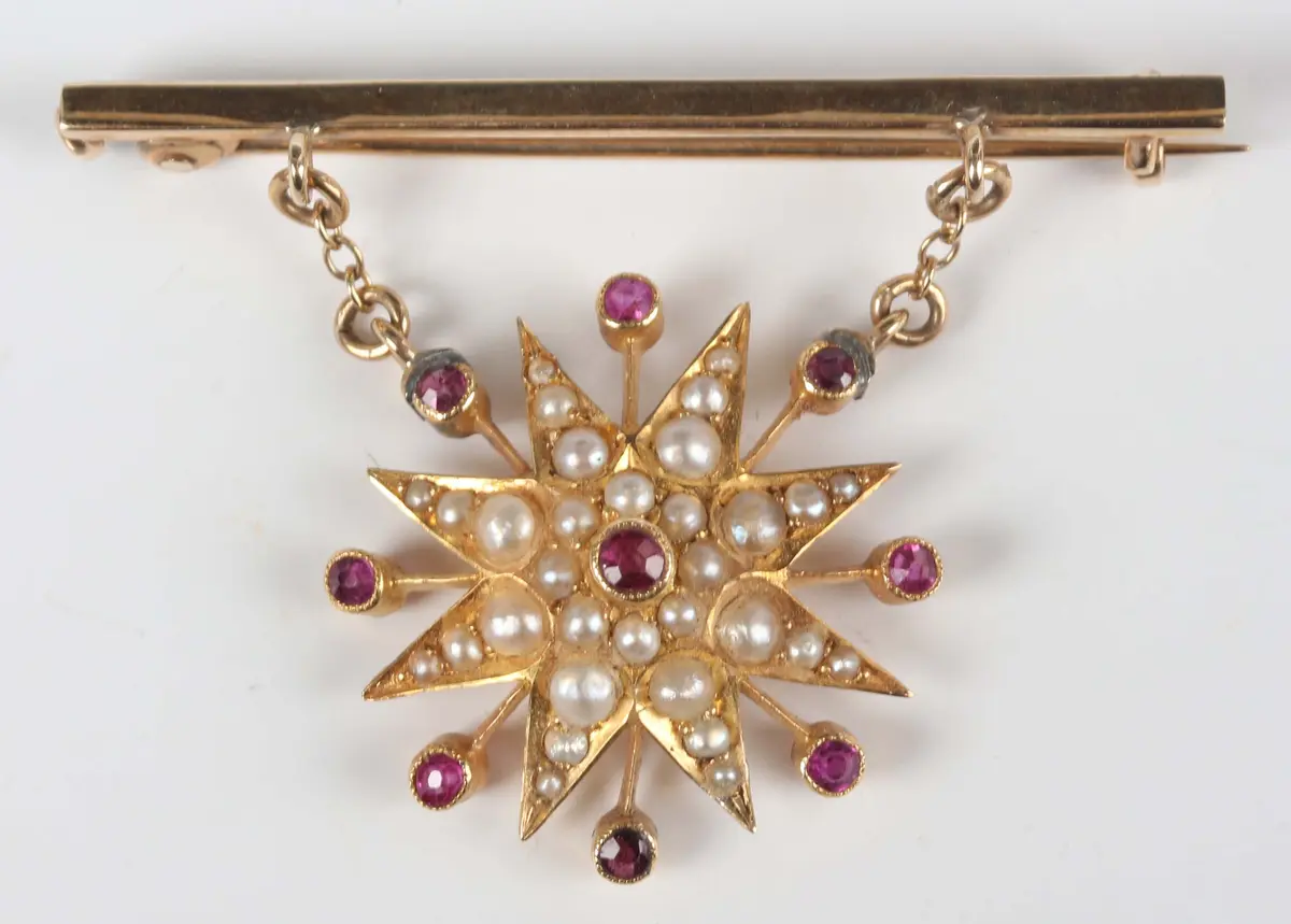 A gold, half-pearl and pink sapphire set starburst pendant, later