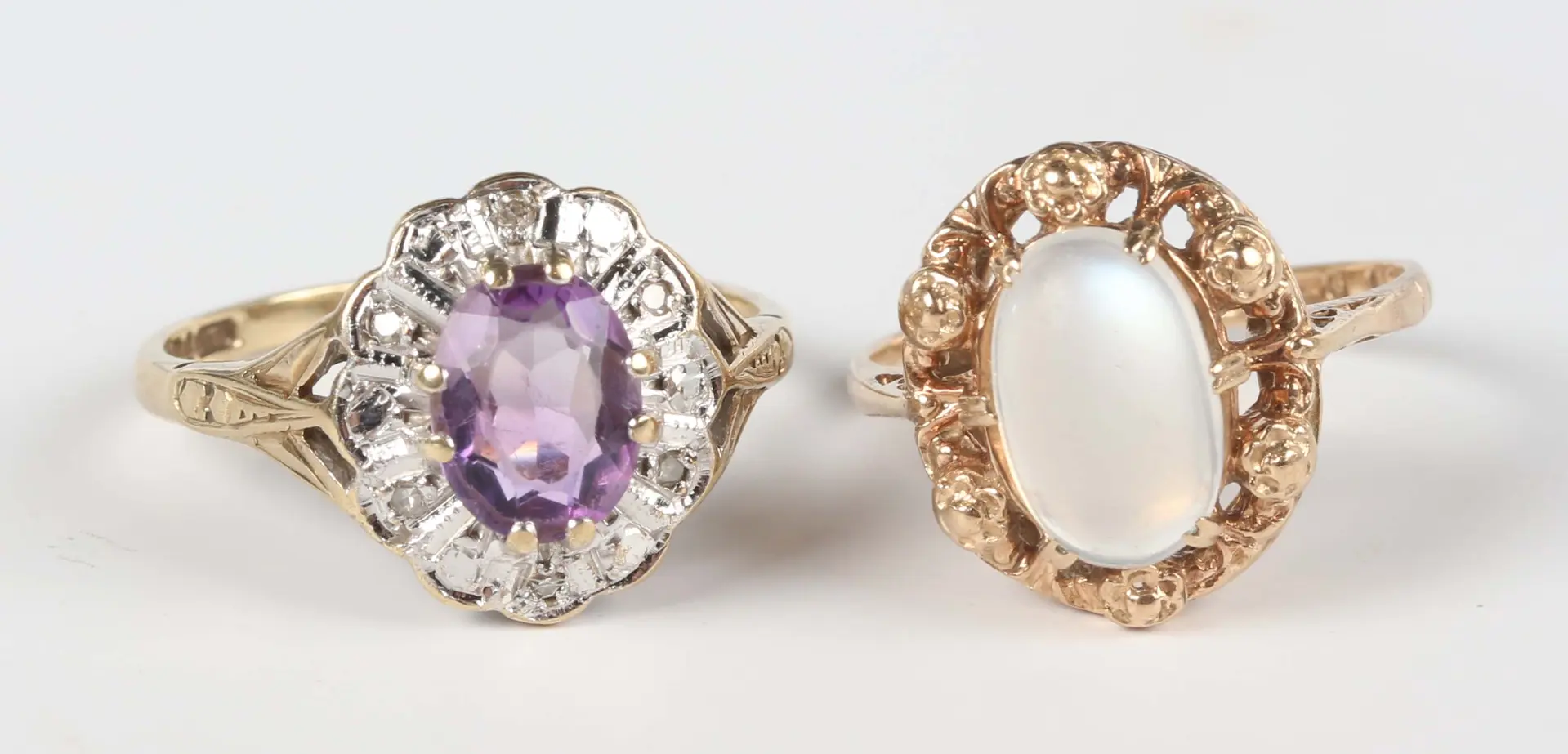 A 9ct gold ring, claw set with an oval moonstone within a floral surround