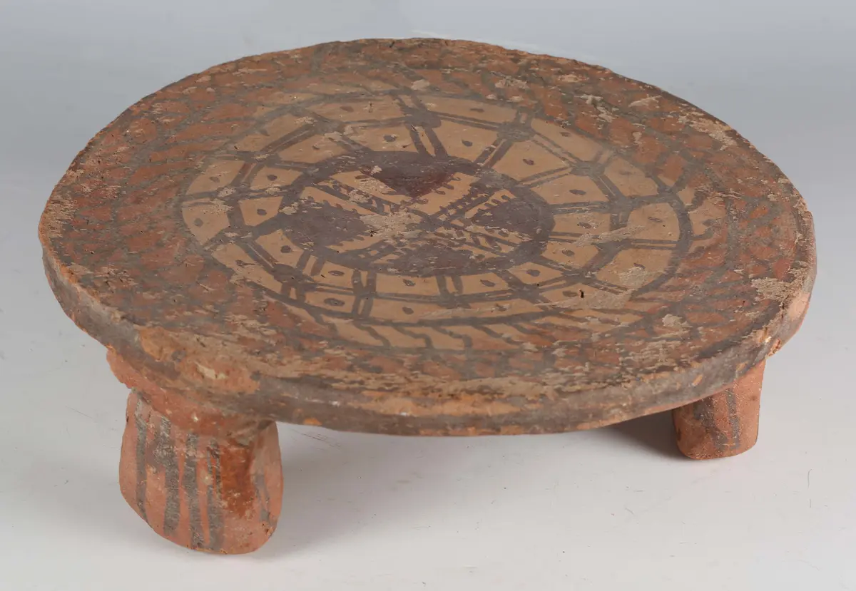 A terracotta circular stand, possibly pre-Columbian, the top with