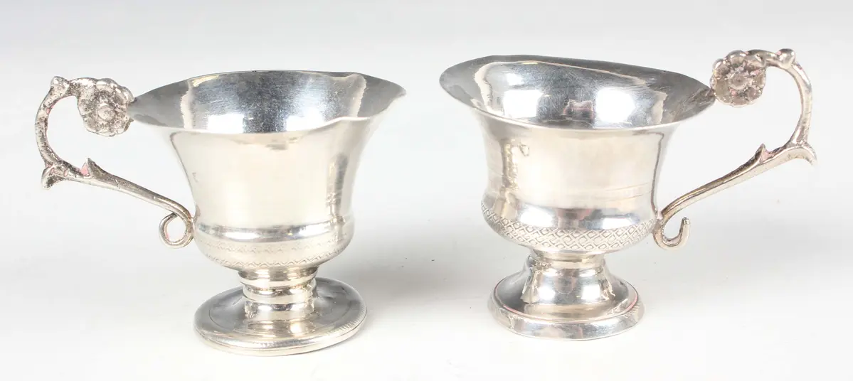 A near pair of Continental miniature toy silver teacups, probably