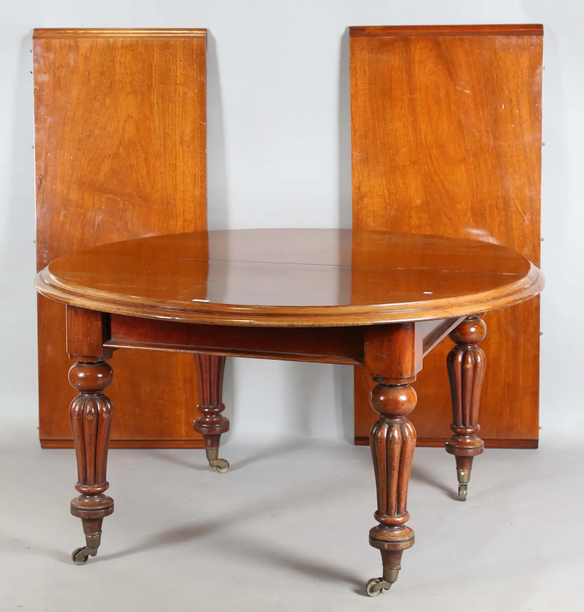 A mid-Victorian mahogany extending dining table, the moulded top with