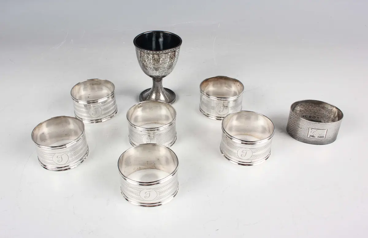 A small group of silver, comprising a set of six napkin rings, each