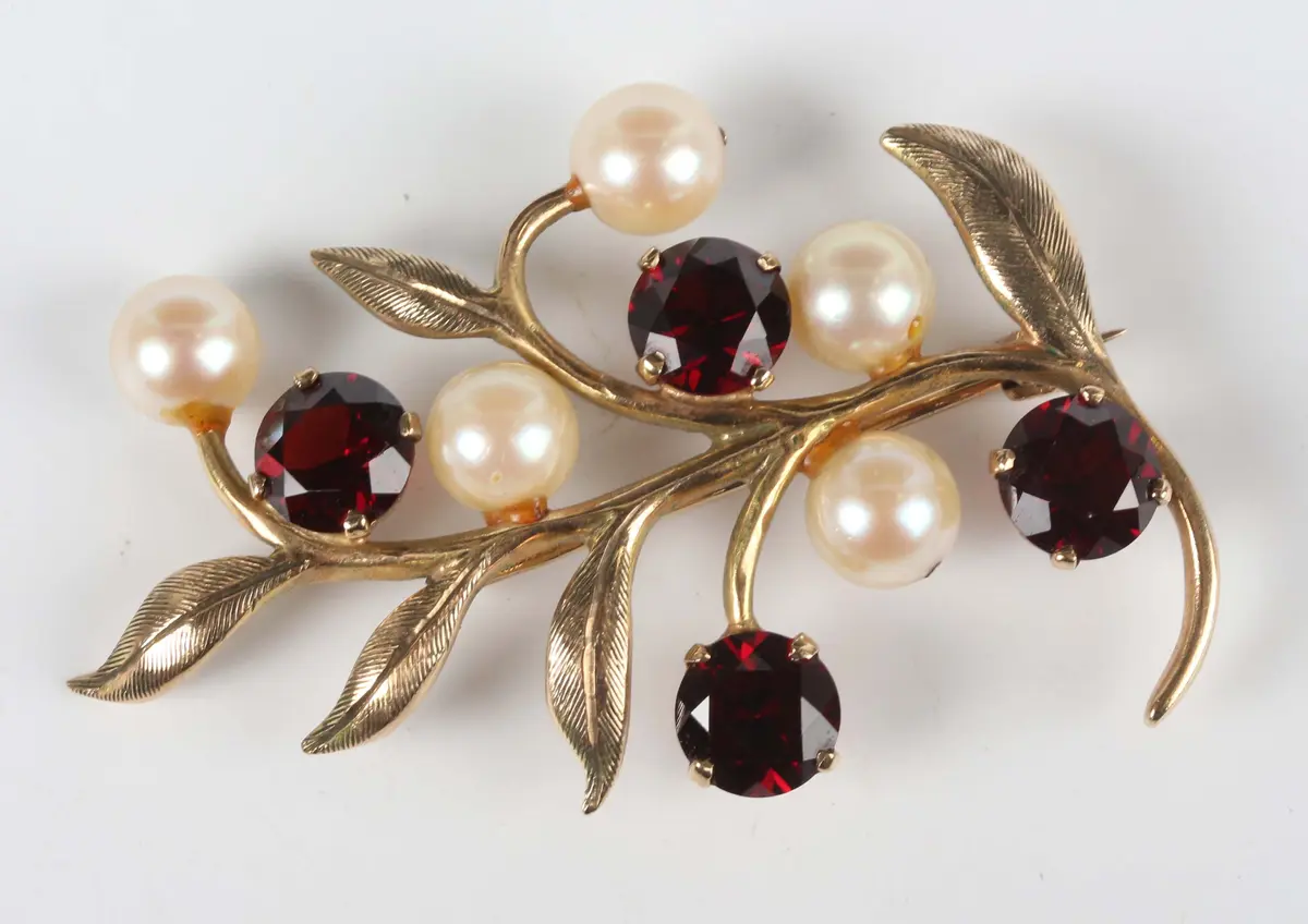 A 9ct gold, garnet and cultured pearl brooch in a foliate spray design