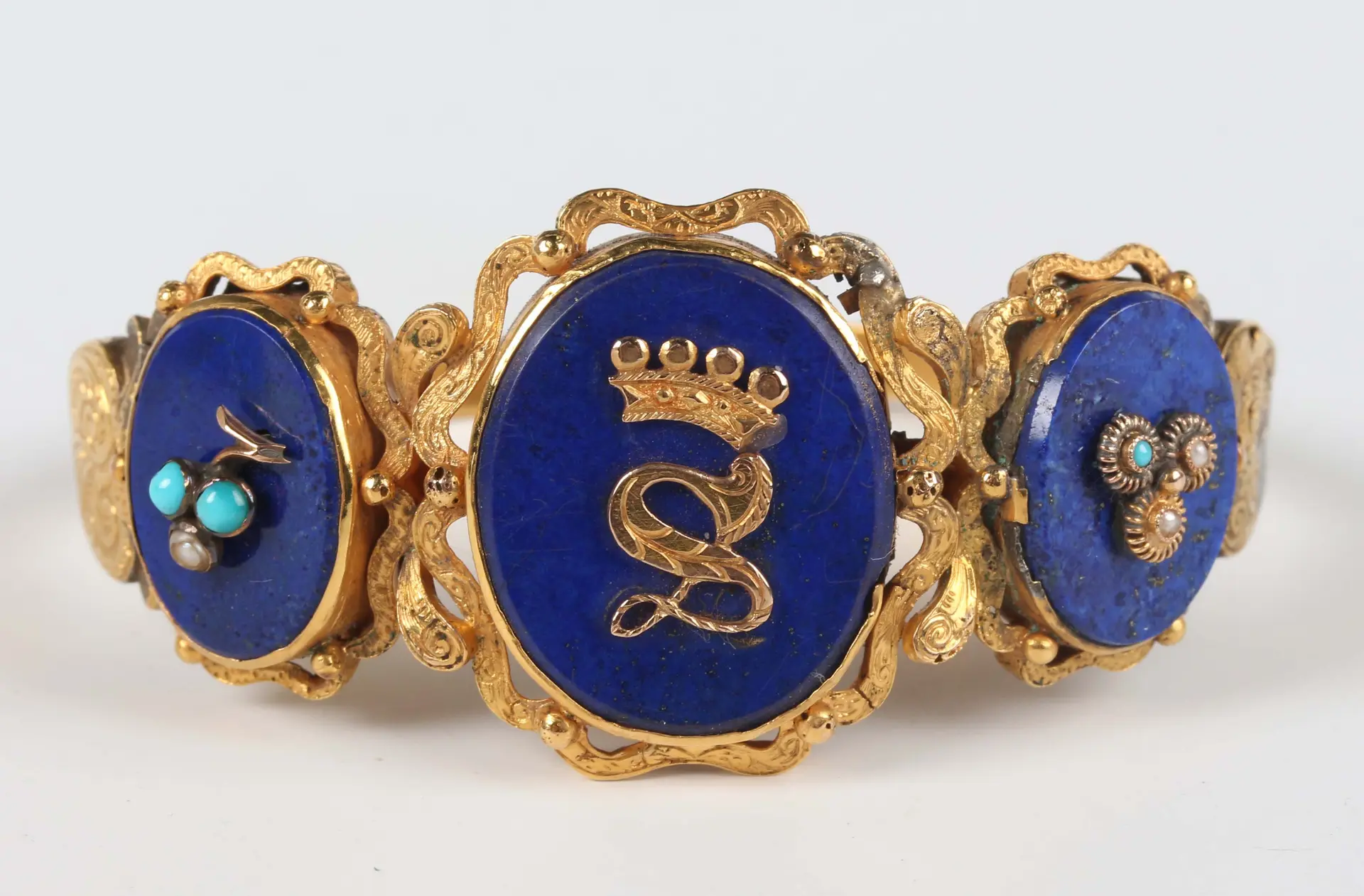 A gold, lapis lazuli, seed pearl and imitation turquoise set oval