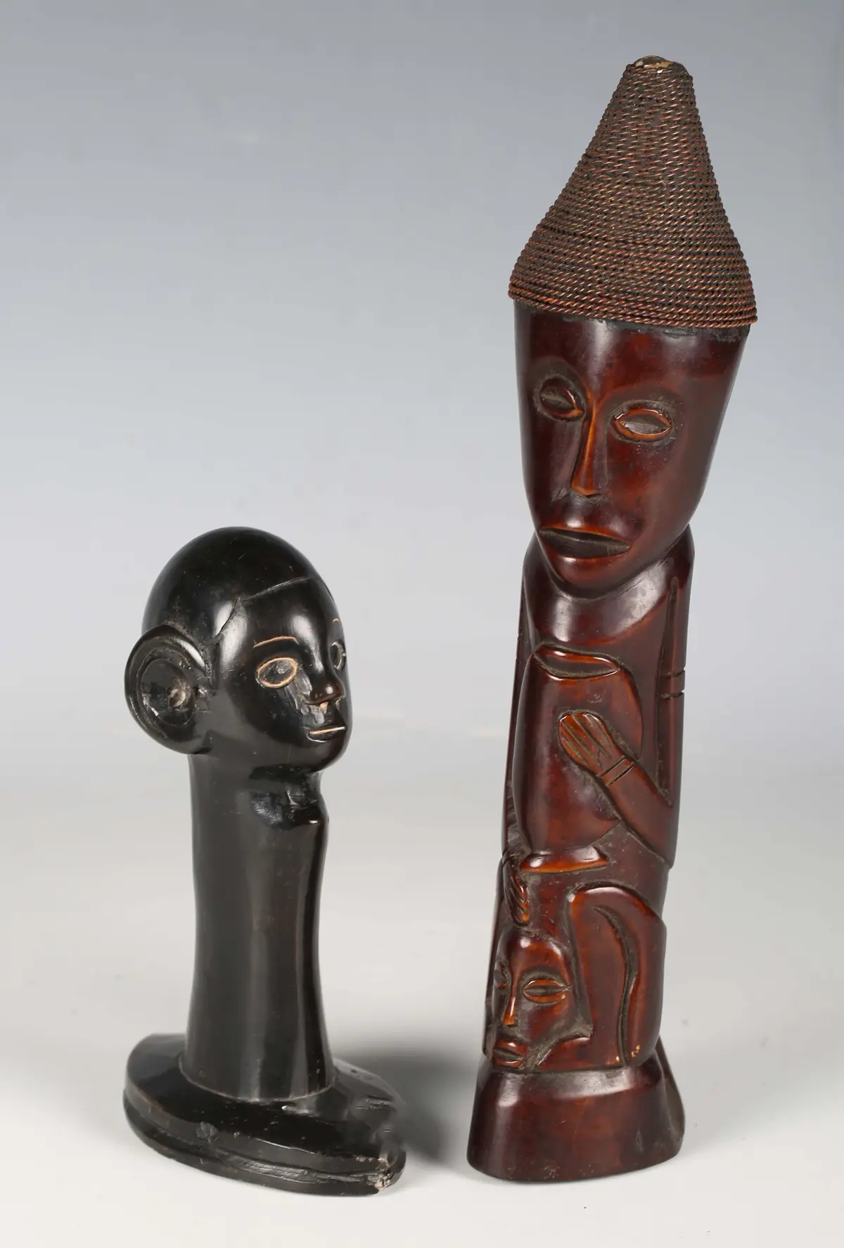 An African carved and stained bone figure group with bound wire headdress