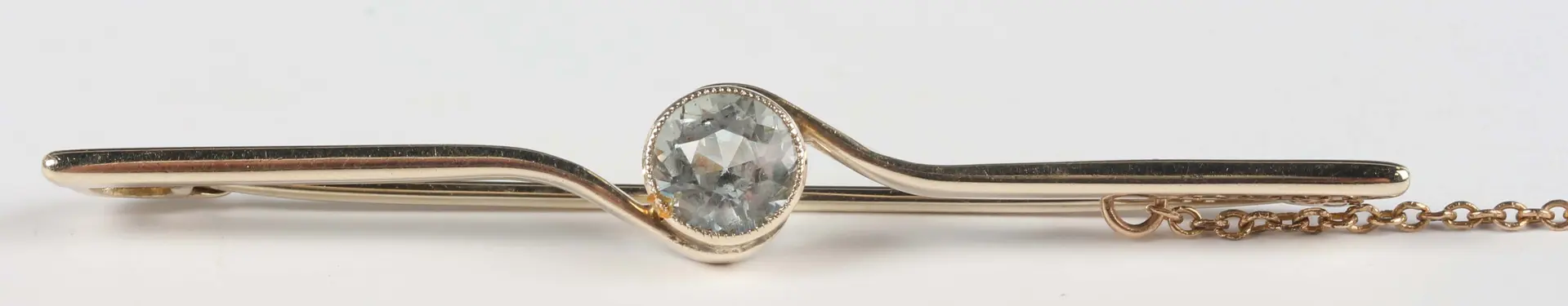 A gold bar brooch, collet set with a circular cut aquamarine at the