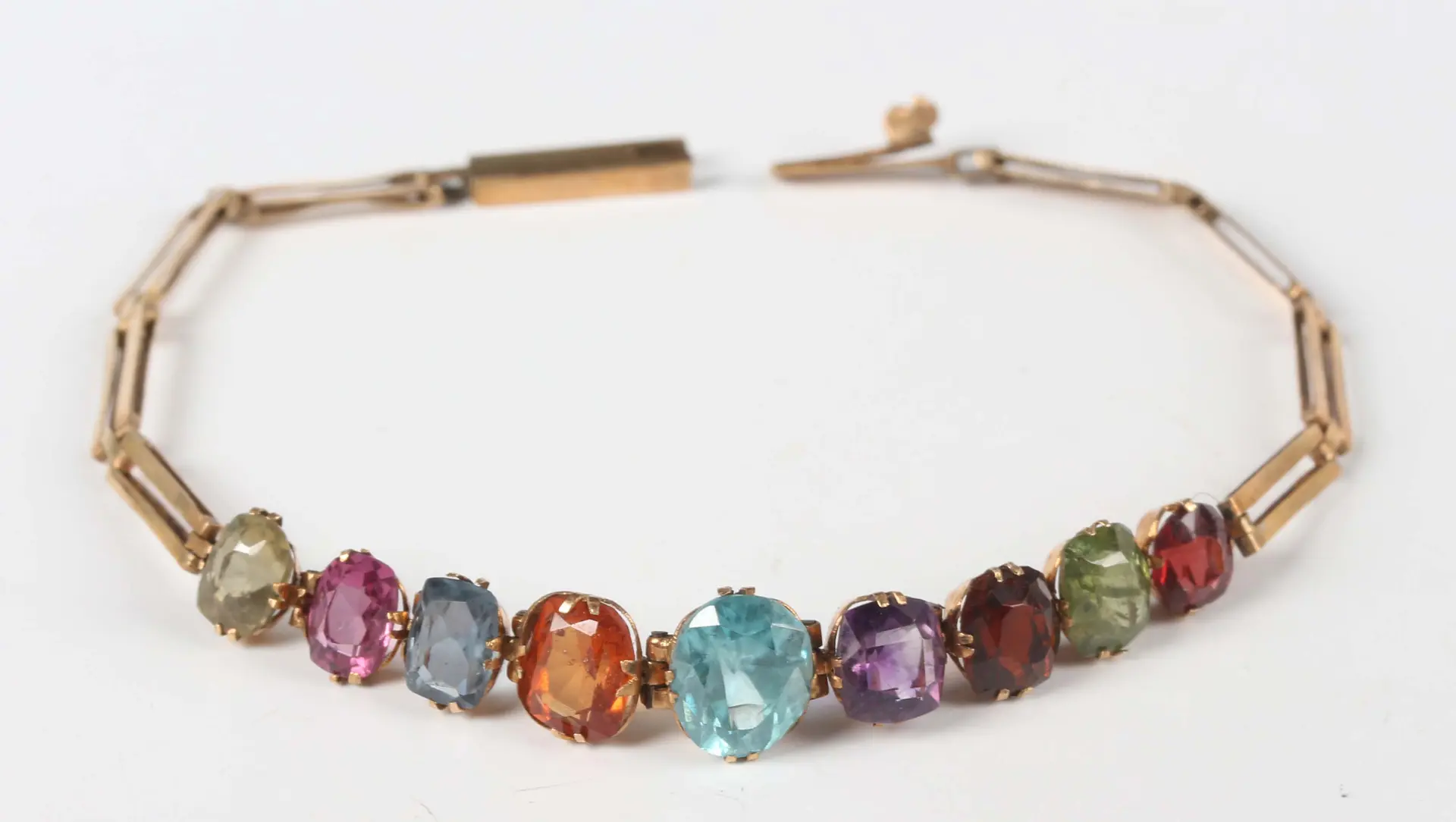 A gold and varicoloured gemstone set bracelet, mounted with a row
