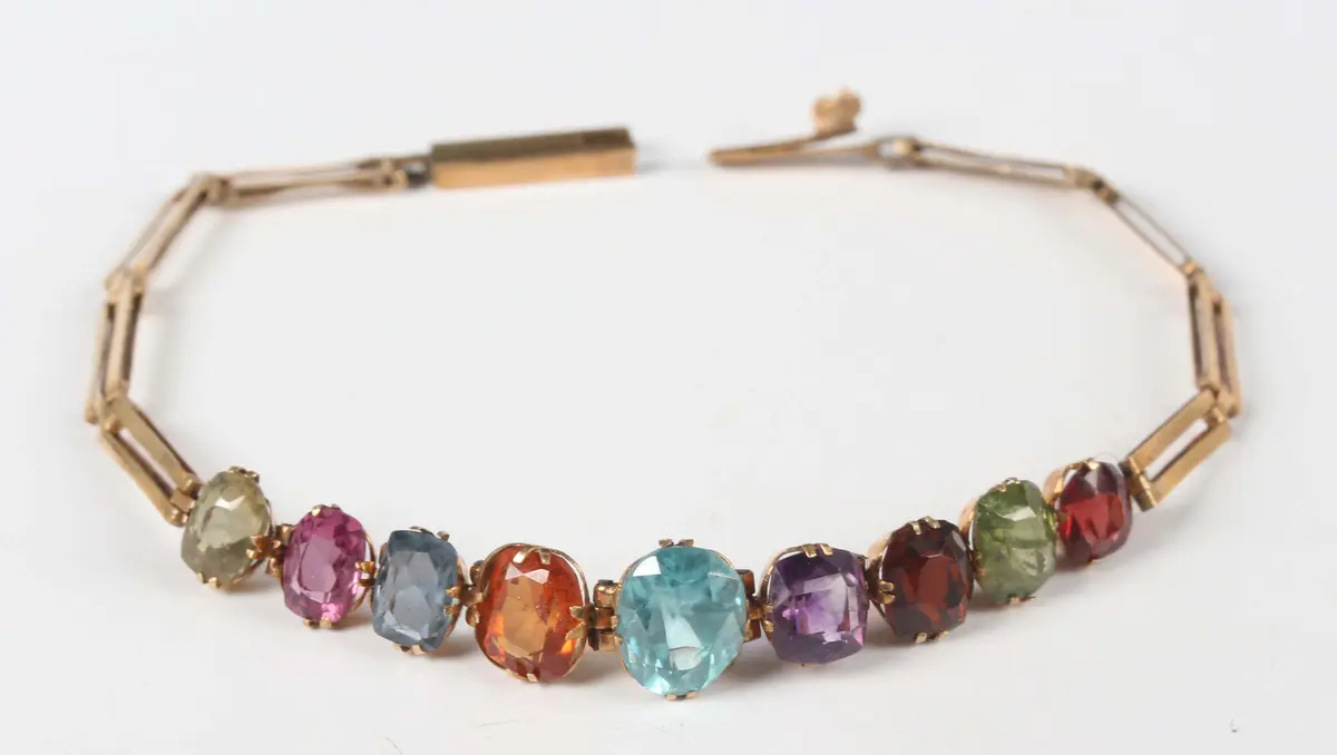 A gold and varicoloured gemstone set bracelet, mounted with a row