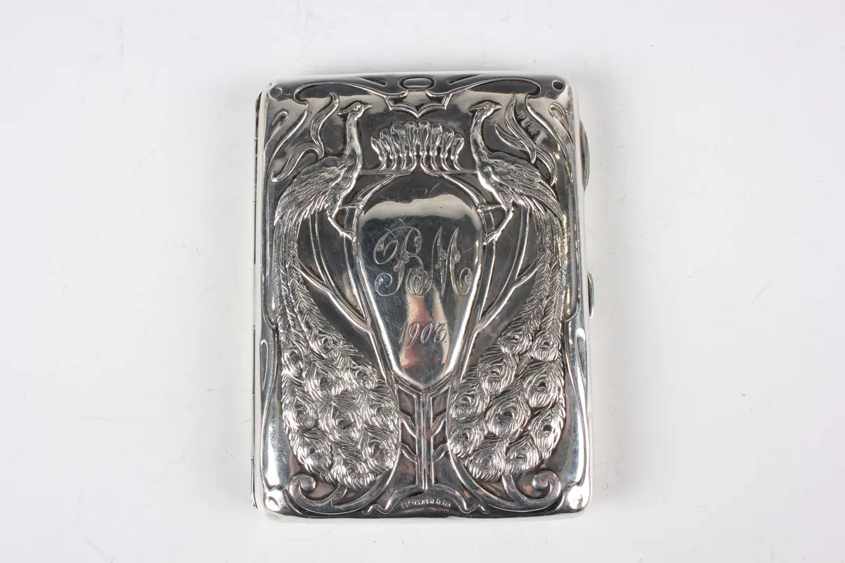 An Art Nouveau silver aide-mémoire, the front embossed with a pair