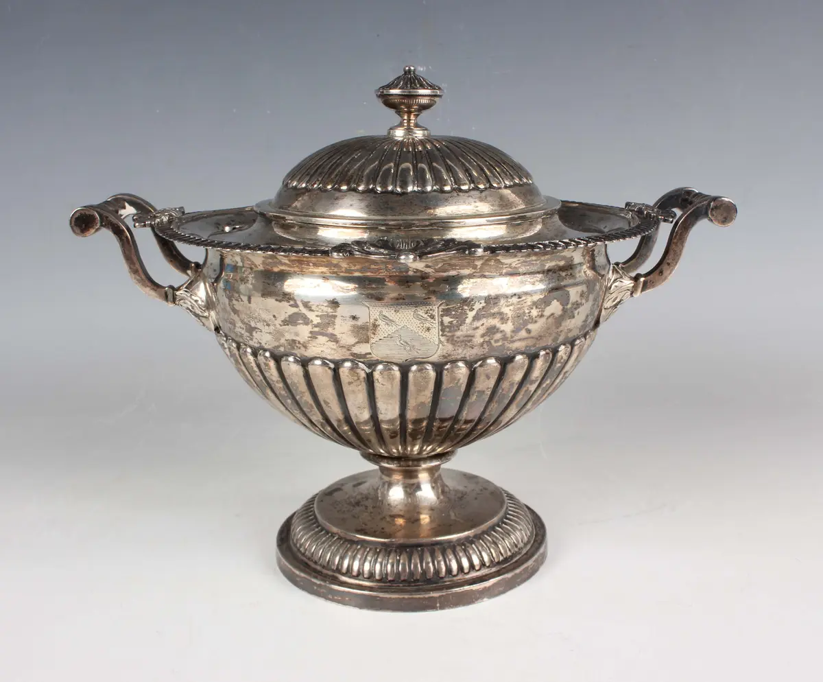 A George III silver sauce tureen and cover of circular half-reeded