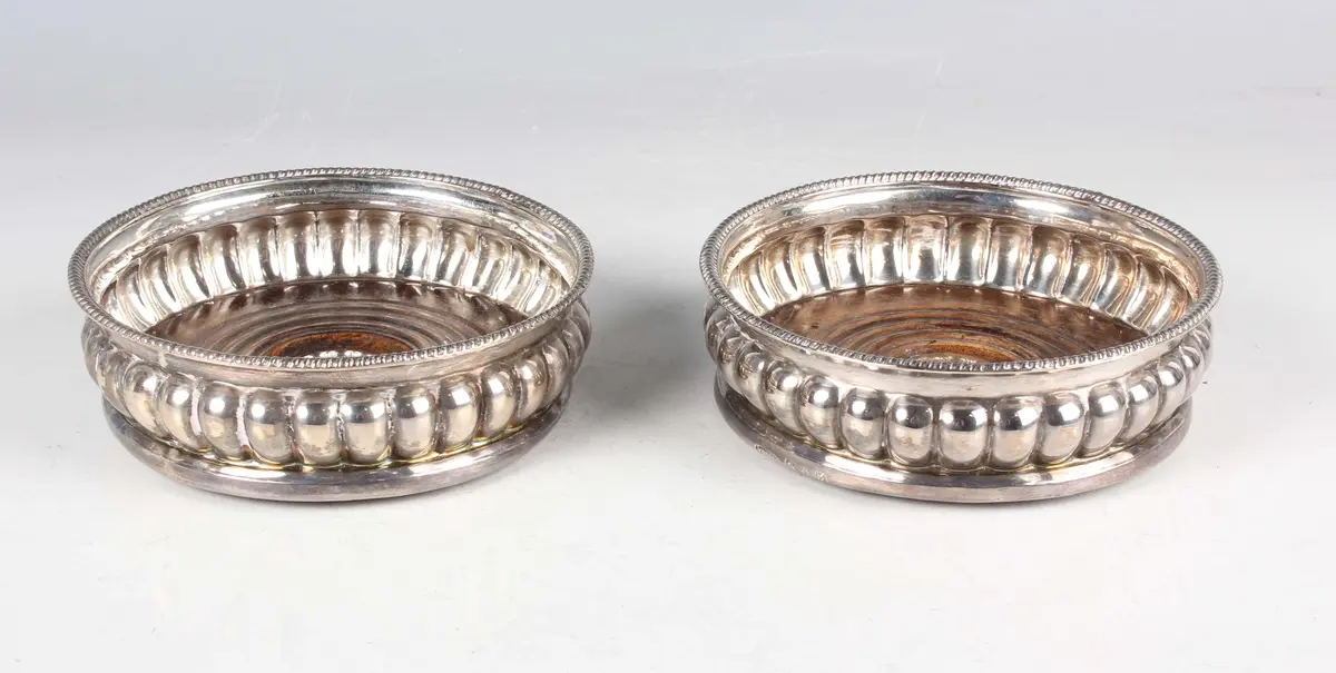 A pair of George III silver wine coasters, each with gadrooned rim