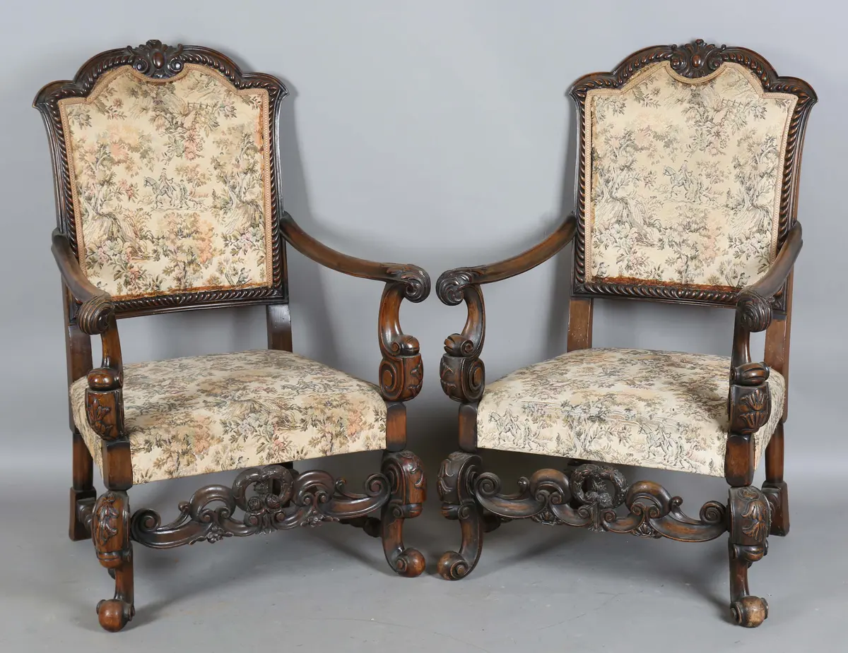 A pair of early 20th century Carolean Revival walnut framed armchairs