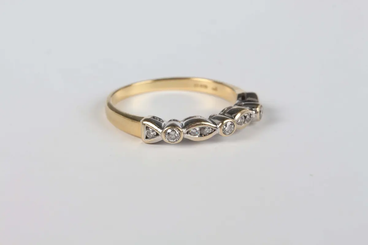 An 18ct gold and diamond half eternity ring, mounted with circular