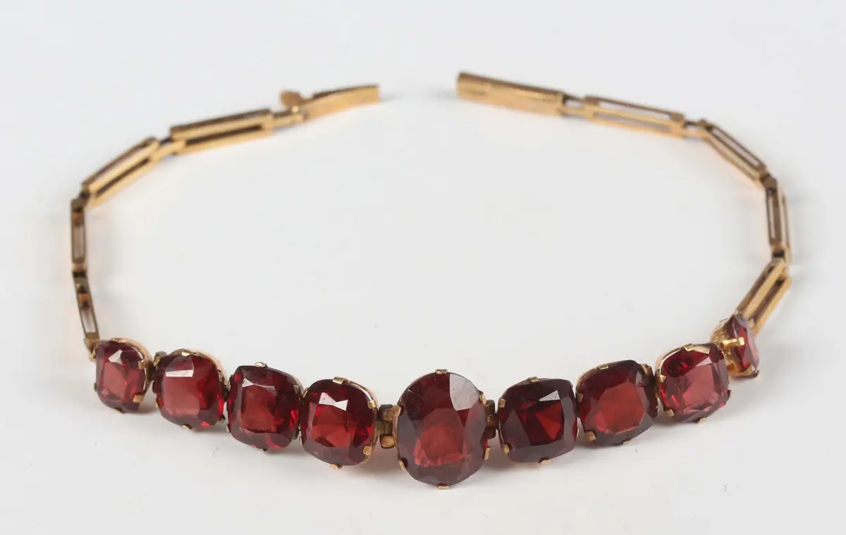 A gold and garnet bracelet, mounted with a row of nine graduating