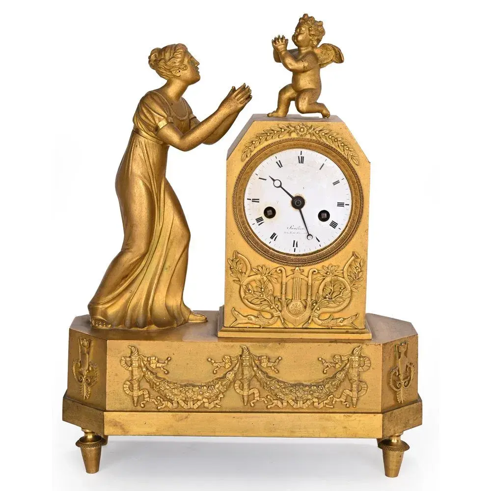 RESTAURATION CLOCK in gilded bronze depicting a woman in classical